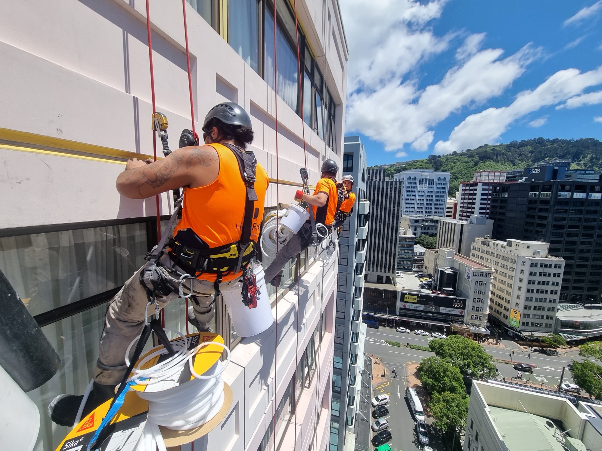 Two Highrise rope access technicians working a building facade