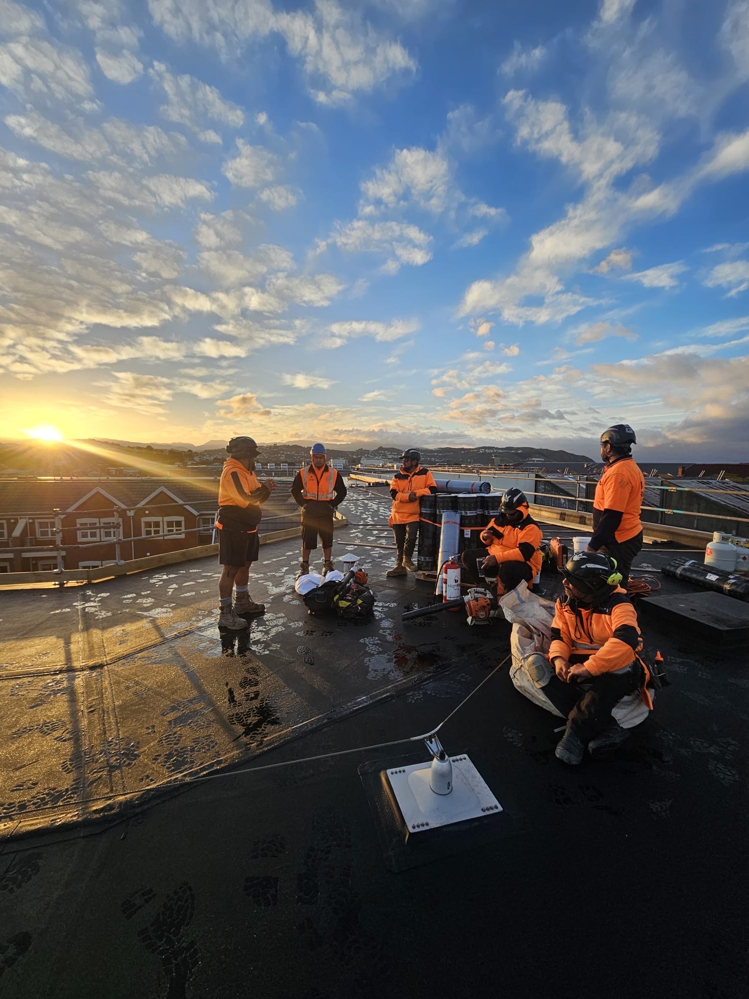 Highrise crew at sunrise on a Wellington roof, Kāpiti Coast