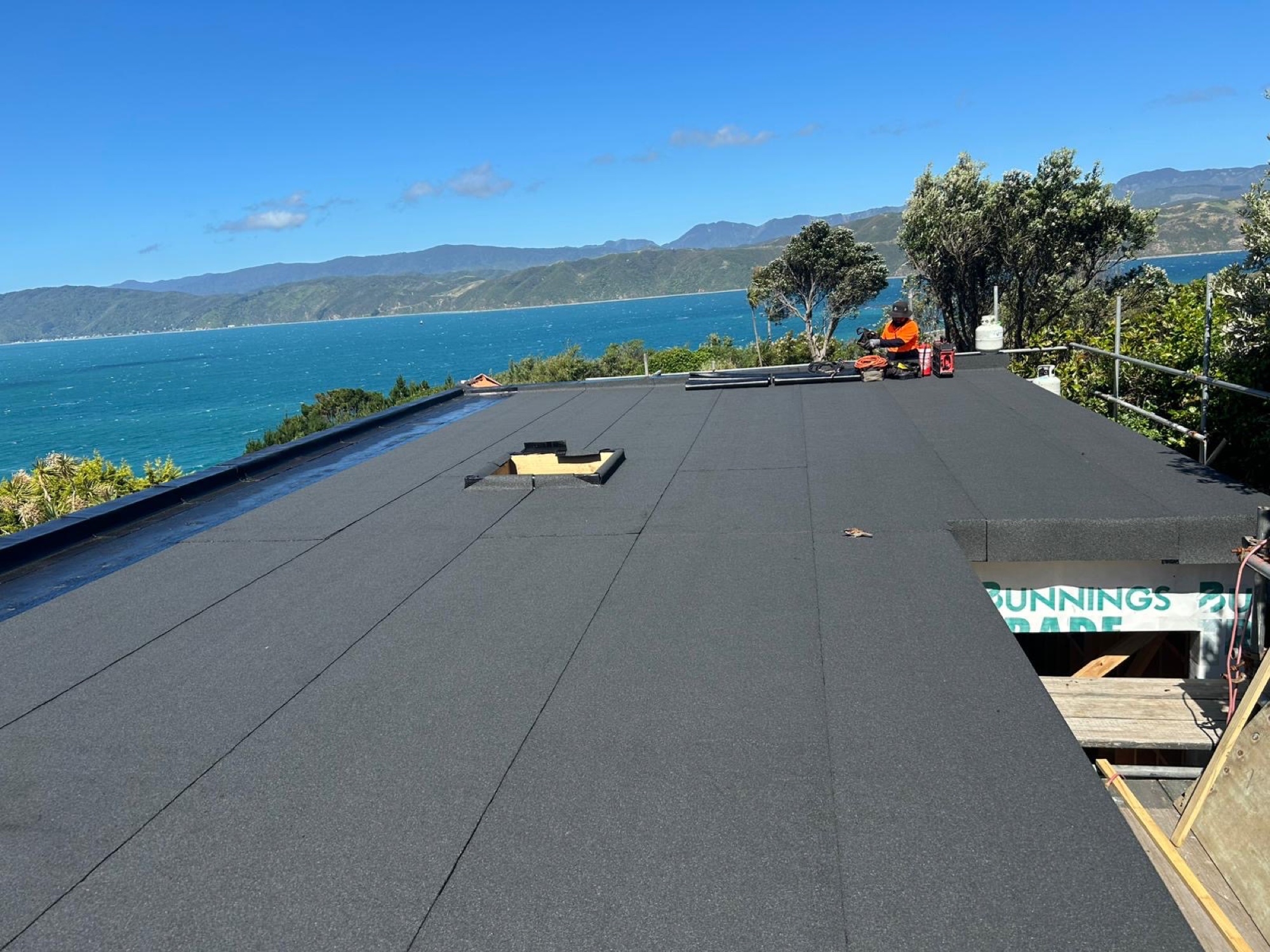 Completed rooftop walkway membrane with lake and hills beyond
